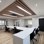 ノリアホームが施工した建設会社の新社屋オフィス。木目天井と白いデスクが並ぶ開放感ある空間