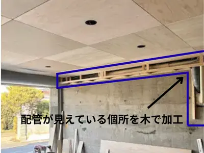 ガレージの天井に木の板が貼られ、配管まわりも木で丁寧に囲われて仕上がった状態を写した写真
