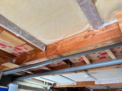 ガレージの天井に露出した配線と照明器具があり、これから板張りで配線を隠すための工事前の状態を写した写真