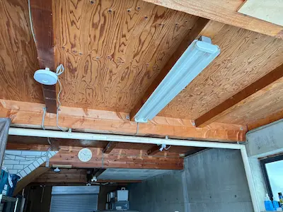 仕上げ材を貼らず、構造材+合板がそのまま天井面として使われているガレージの天井