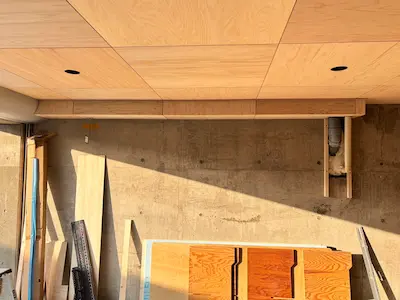 ガレージの天井に木の板が貼られ、配管まわりも木で丁寧に囲われて仕上がった状態を写した写真