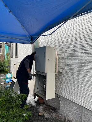 雨の日にボイラーの交換工事をしている様子